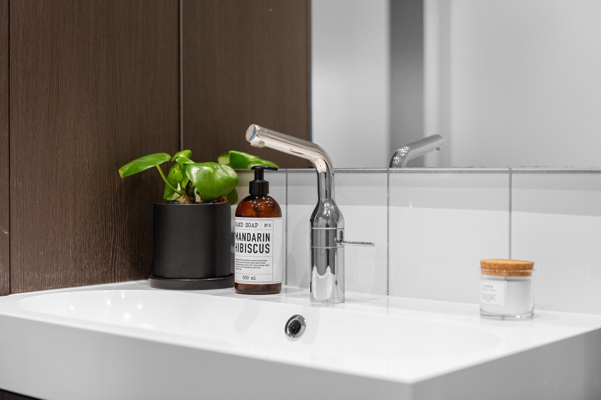 Rommet har grå gulv- og sokkelfliser, hvite veggfliser, termostatstyrt gulvvarme, og led-downlights. Galleribilde