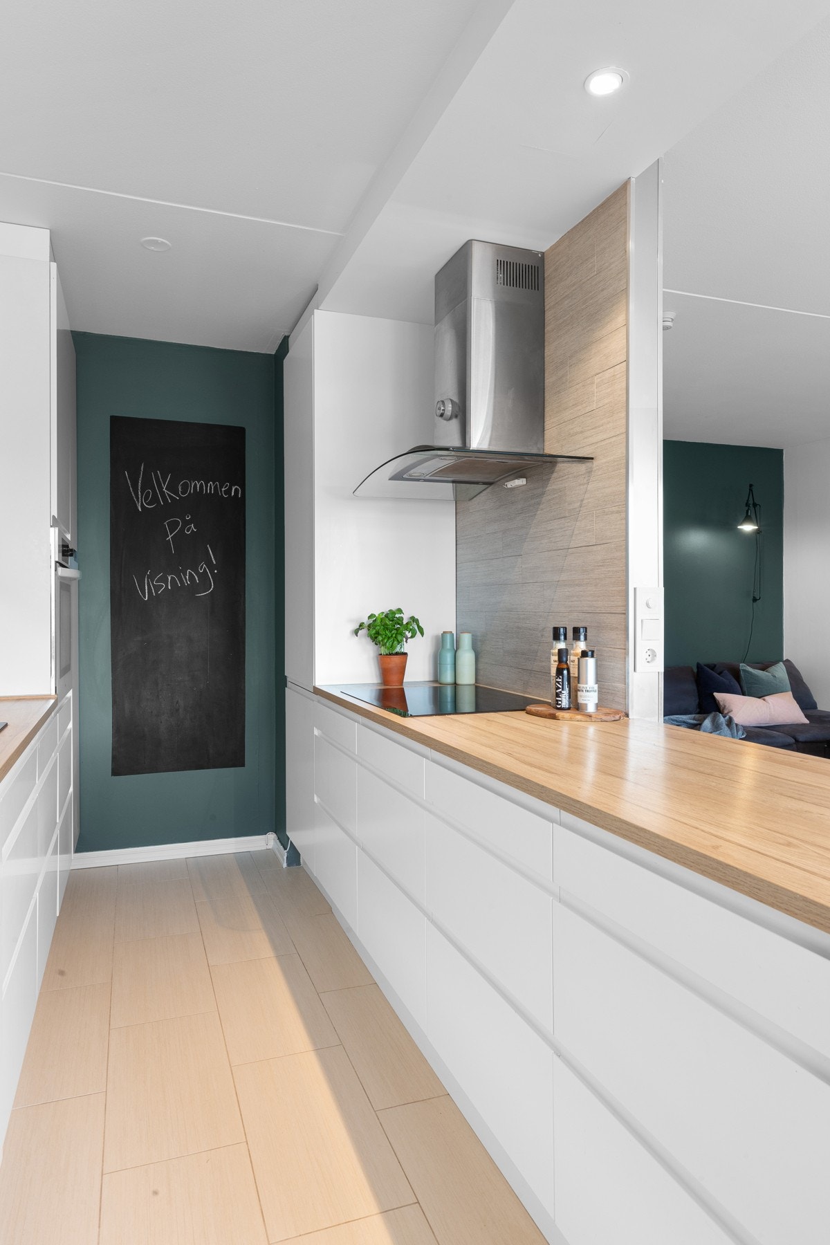 Mellom over- og underskap er det montert belysning og strømuttak, og over benker er det lysegrå fliser til overskap og himling. Galleribilde