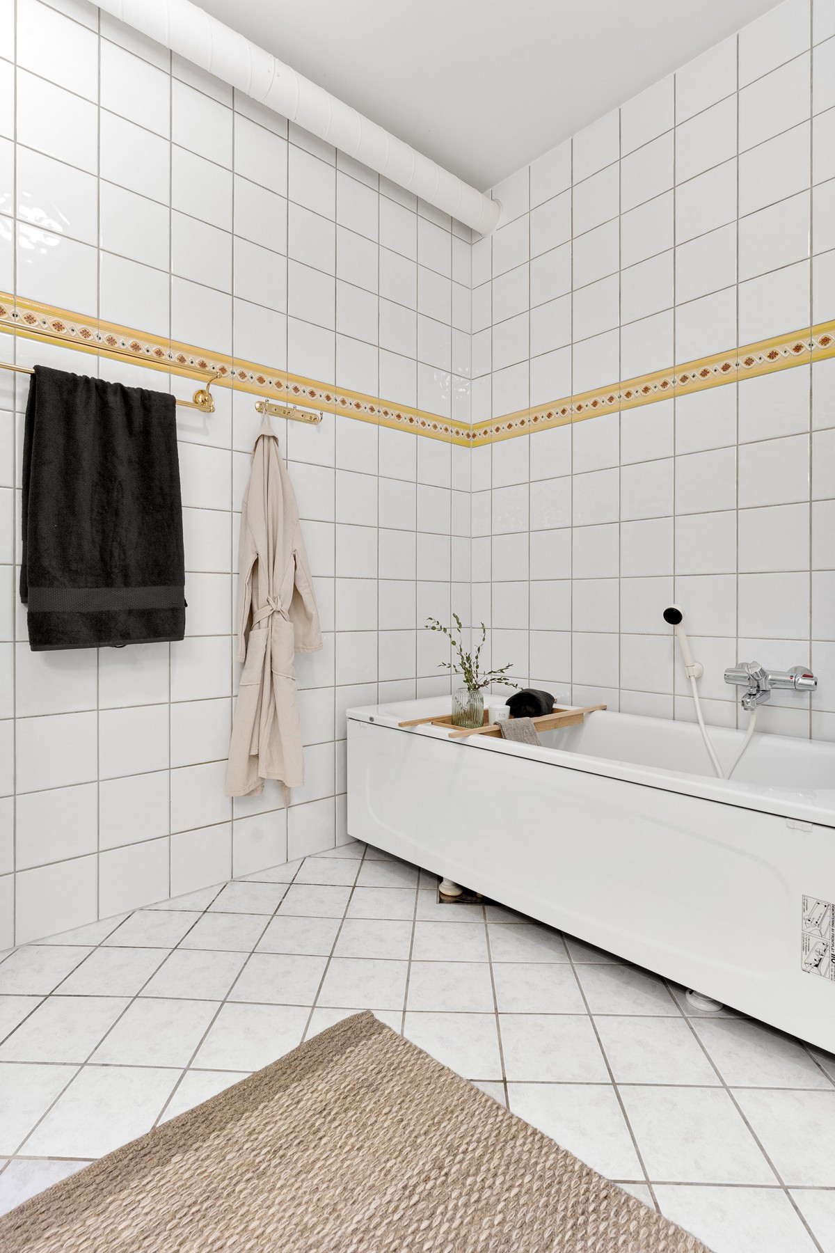 Badet er innerdet med badekar, dusjkabinett og toalett