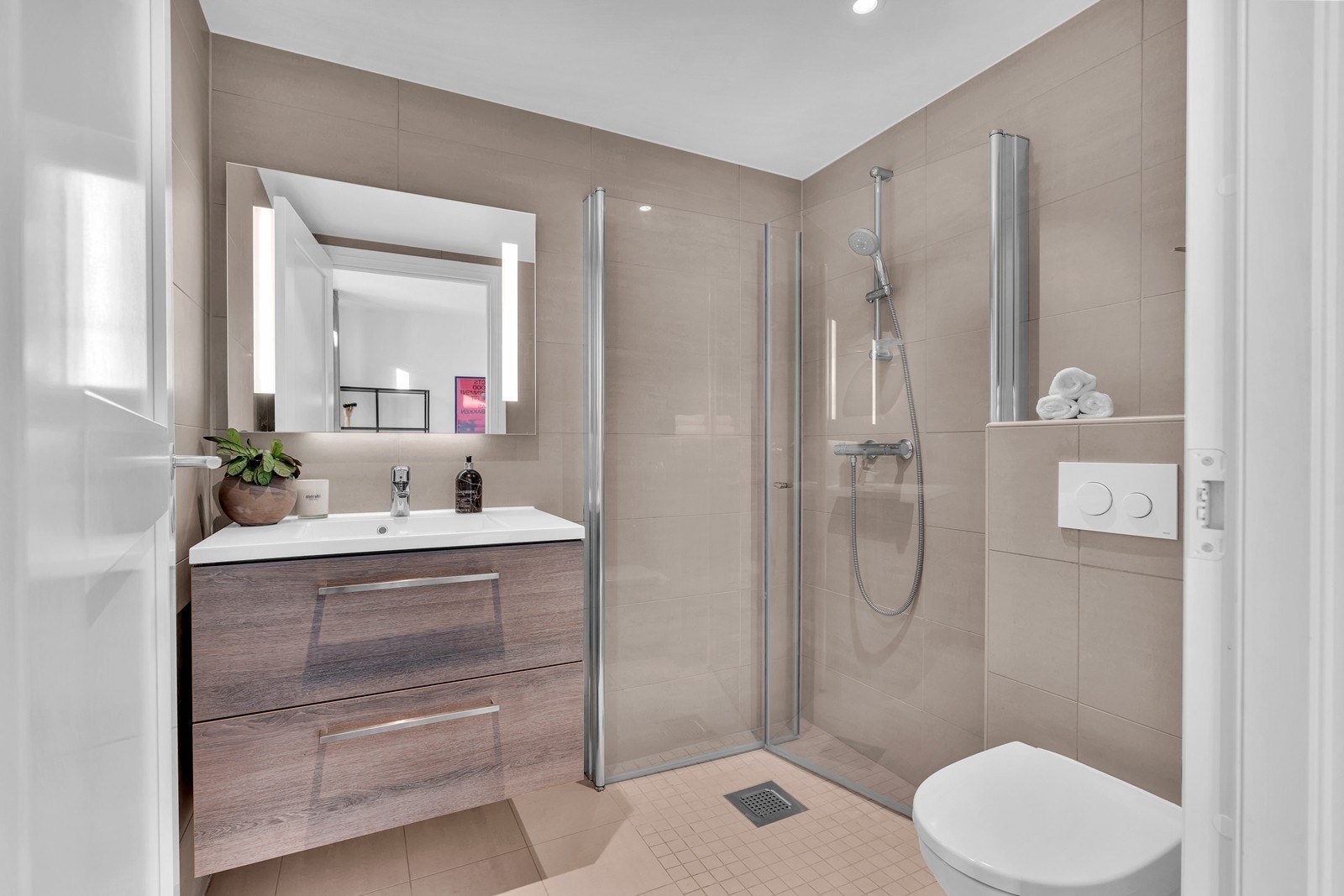 Badet har en lekker tidsriktig utførelse med vannbåren varme i gulv, delikat materialvalg med moderne fliser og innredning Galleribilde