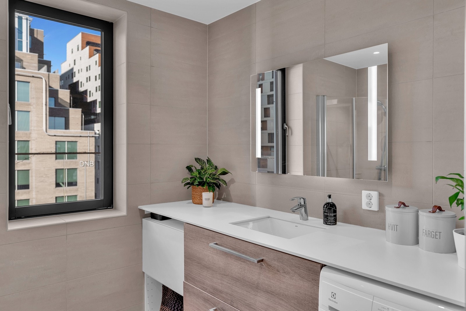 Badet er videre utstyrt med vegghengt toalett, dusjhjørne med glassdører, samt servant med underskap som sørger for godt med lagringsplass Galleribilde