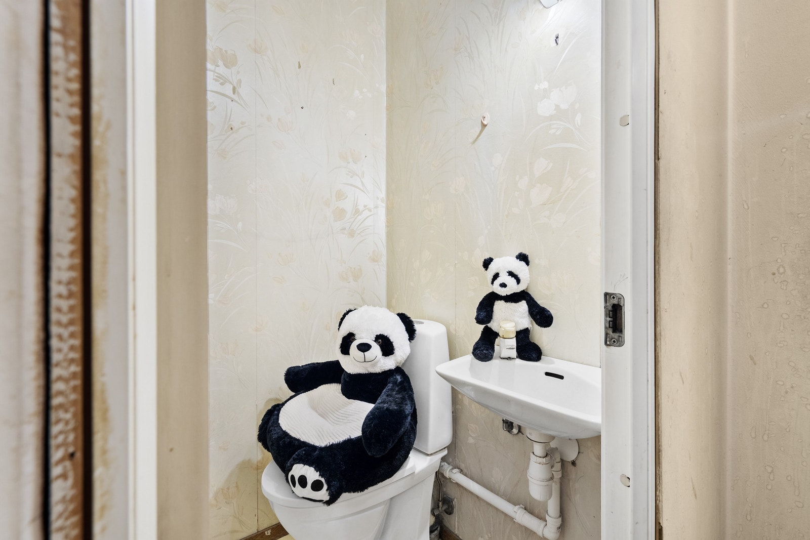 Toalettrom som er innredet med gulvstående toalett og vegghengt servant Galleribilde