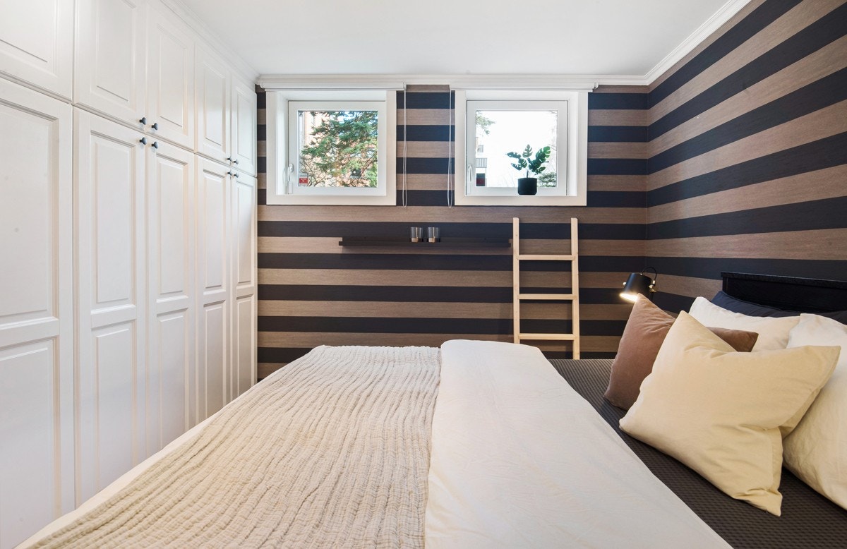 Dette soverommet har en stor rikelig med garderobeplass og stilren tapet på veggene. Galleribilde