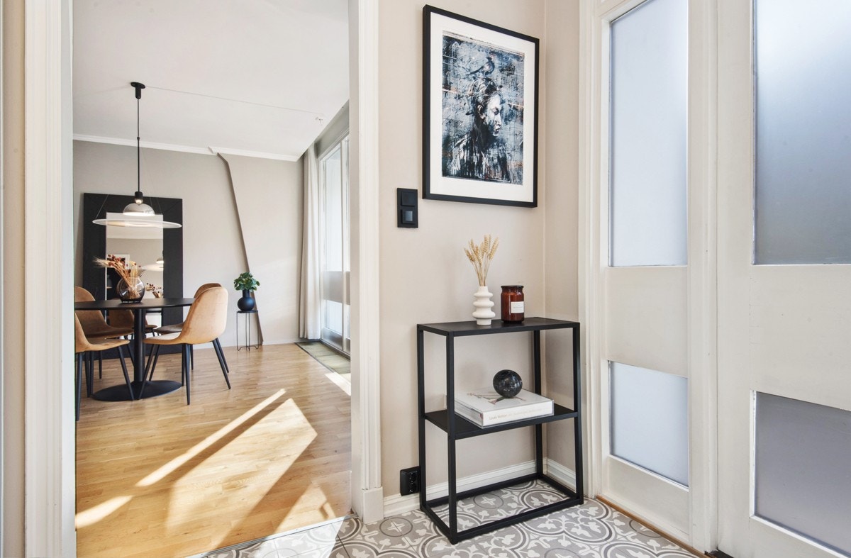 Lyst og stilrent inngangsparti med historiske fliser på gulv. Galleribilde