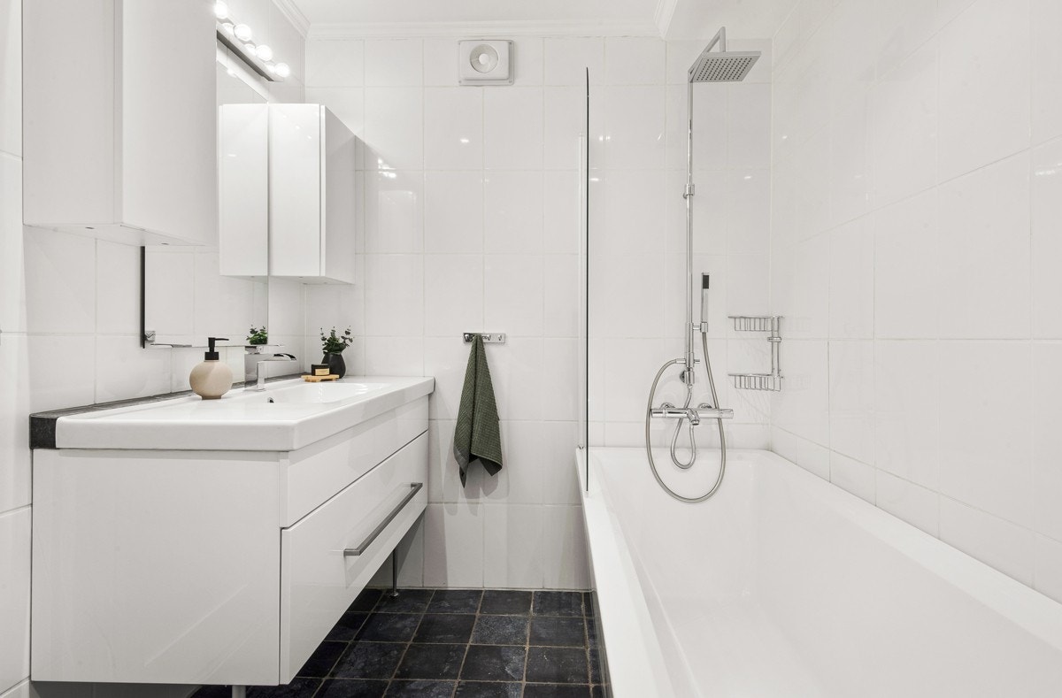 Pent flislagt baderom med badekar og opplegg til vaskemaskin. Galleribilde