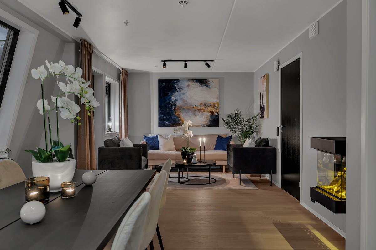 Stuen har naturlige soner for innredning av sofagruppe og stort spisebord.