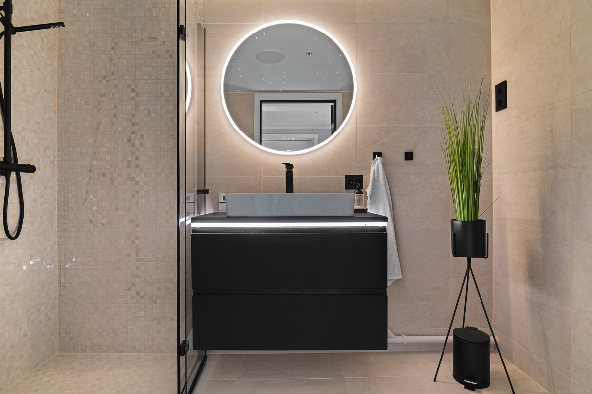 Meget lekkert og påkostet flislagt bad med nydelige fargekombinasjoner og moderne detaljer som sorte glassdører i dusjsonen, sort blandebatteri med rainshower og sorte knagger