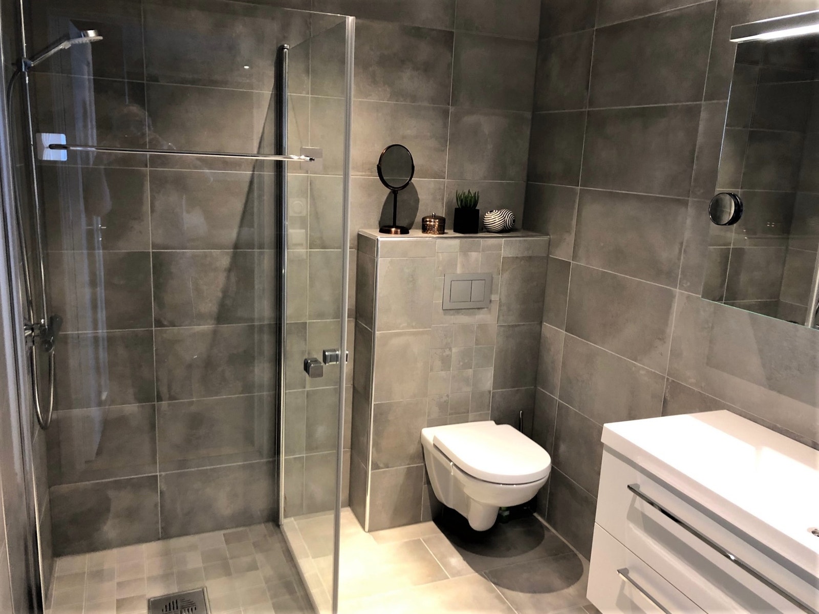 Bad 2. Stort, lekker flislagt bad med takdusj/hånddusj, vegghengt toalett, romslig servantskap og godt med kroker til håndklær Galleribilde