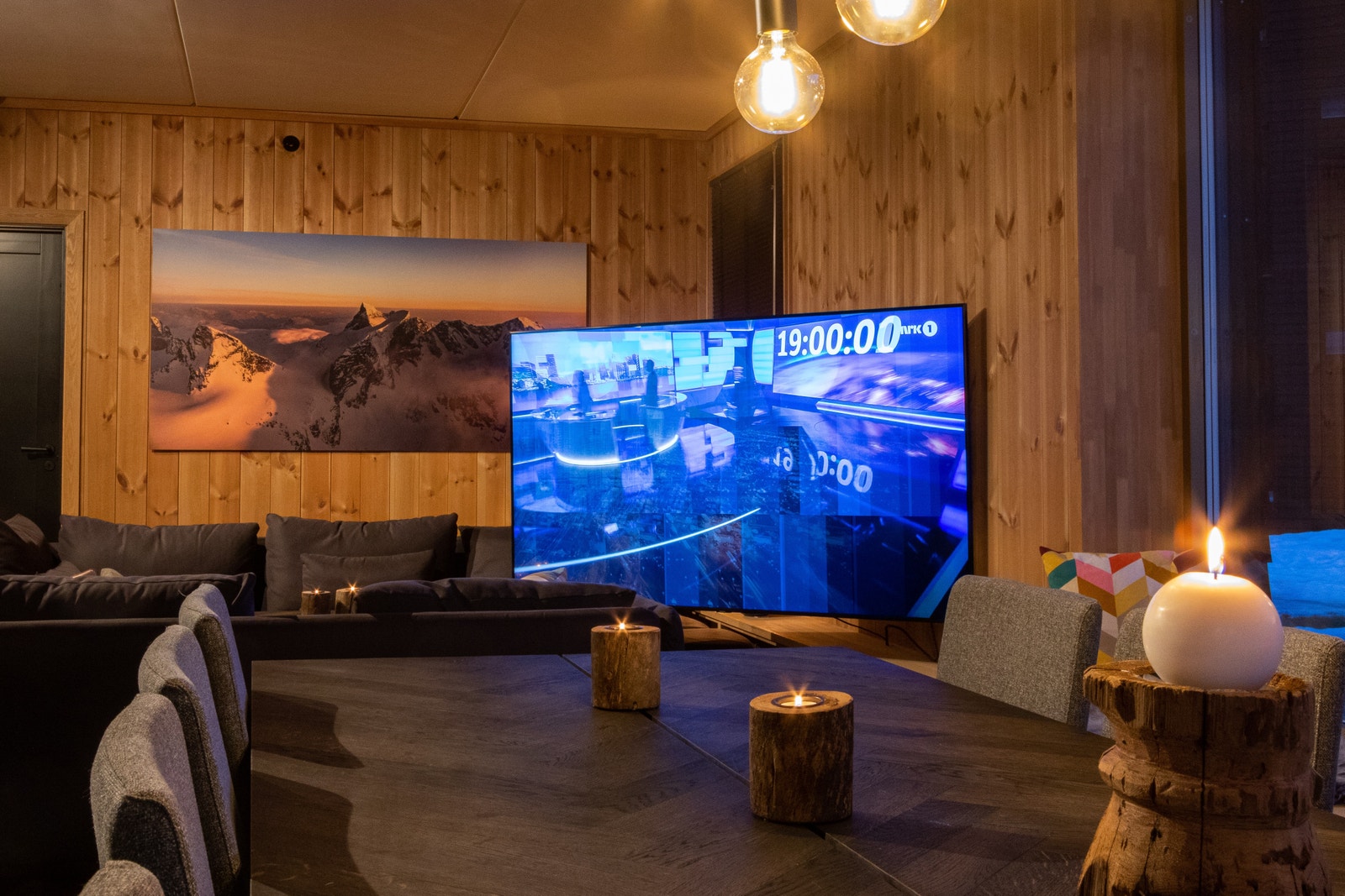 Stue med veggmontert vendbar TV. Tv er på 75 og er tilkoblet kabeltv. Det er også bredbånd i leiligheten Galleribilde