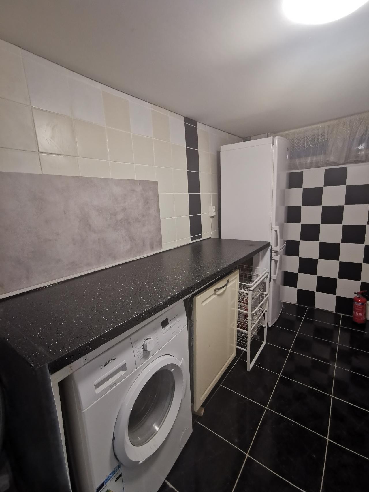 Kjøkken med vaskemaskin, oppvaskmaskin og stor kjøleskap Galleribilde