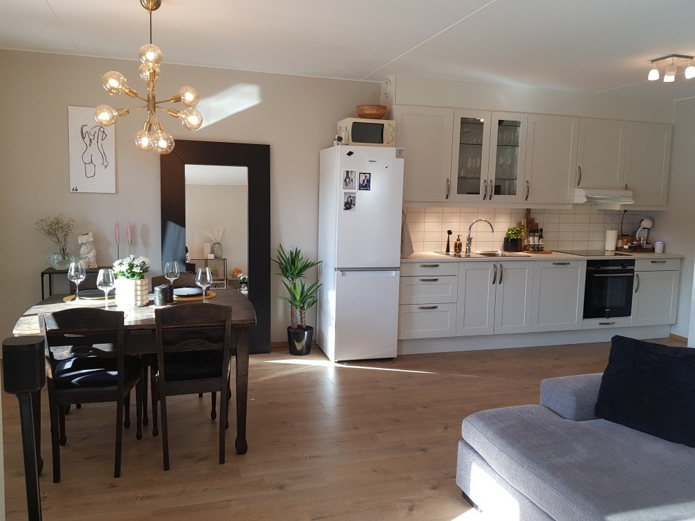 Spiseplassen og kjøkkenet sett fra delen hvor det er sofa og TV. Galleribilde