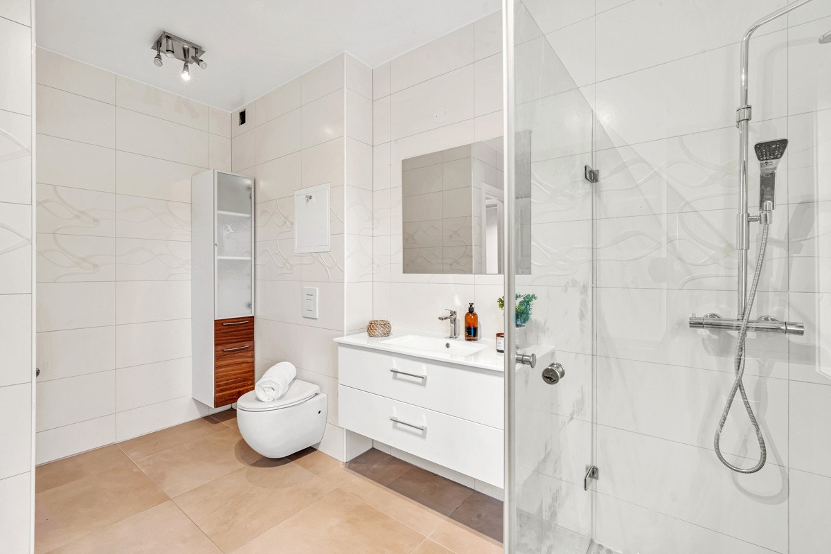 1.etasje | Stilrent bad med gulvvarme, vegghengt toalett, opplegg for vaskemaskin og dusjhjørne med regnfallsdusj. Galleribilde