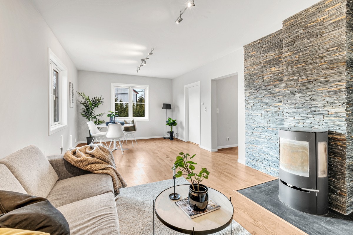 1.etasje | Lune kvelder sikres av en nyere peisovn. Veggen bak ildstedet er kledd i grå teglstein. Galleribilde