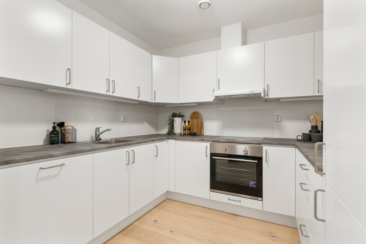 Kjøkken med lyse slette fronter samt god plass til oppbevaring i over- og underskap. Galleribilde