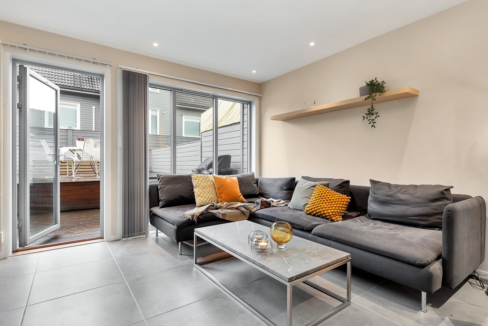 Stue og kjøkken har store flotte fliser på gulv med varmekabler samt spotter i tak Galleribilde