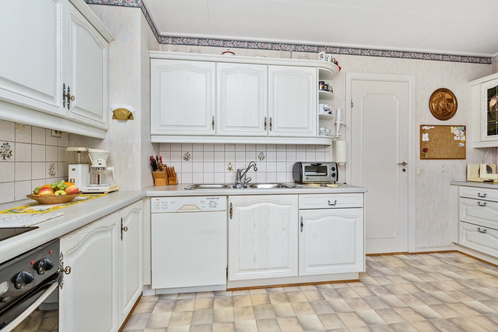 Det er montert fliser på vegg mellom benkeplater og overskap Galleribilde