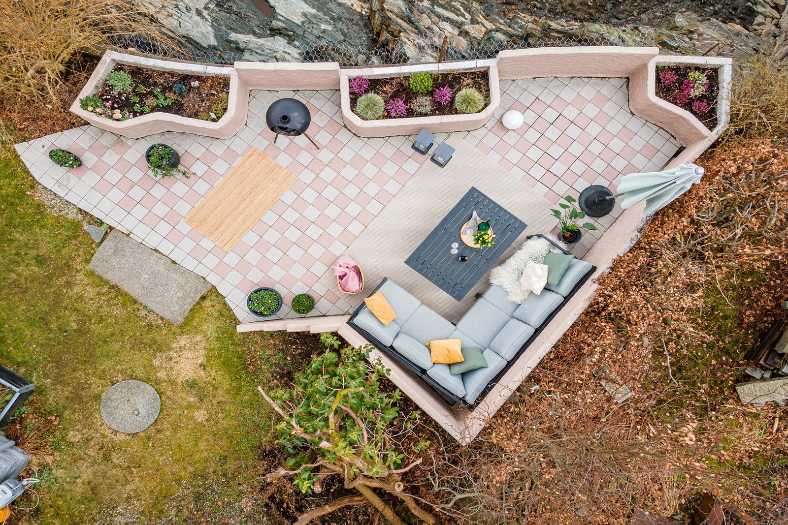 Hagen er opparbeidet med flisbelagt terrasse, grøntareal og beplanting Galleribilde