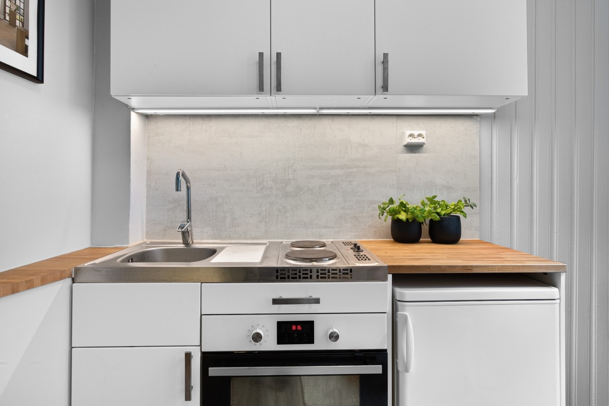 Benkeplate i heltre og integrerte kokeplater, stekeovn og avsatt plass for kjøleskap. Galleribilde