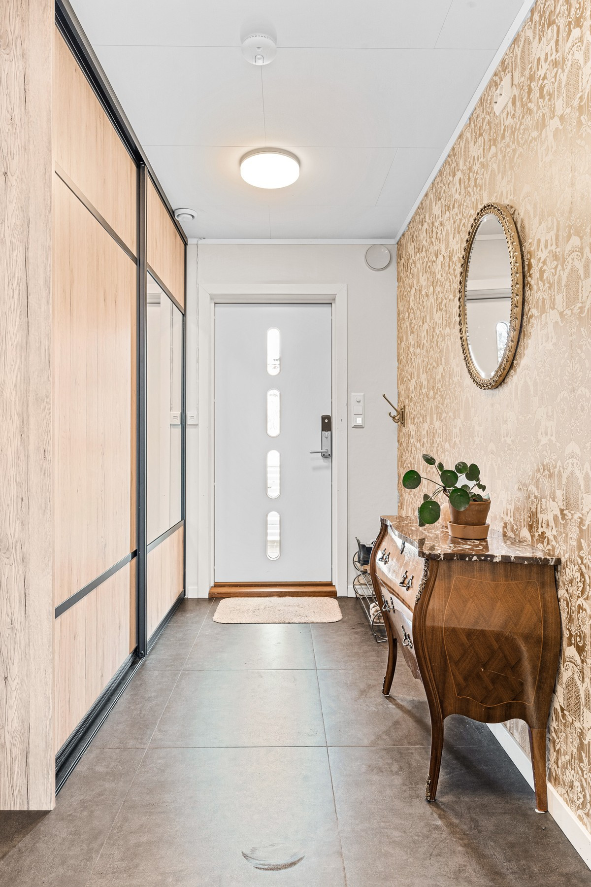 Flislagt entre med varmekabler i gulv og god skyvedørsgarderobe