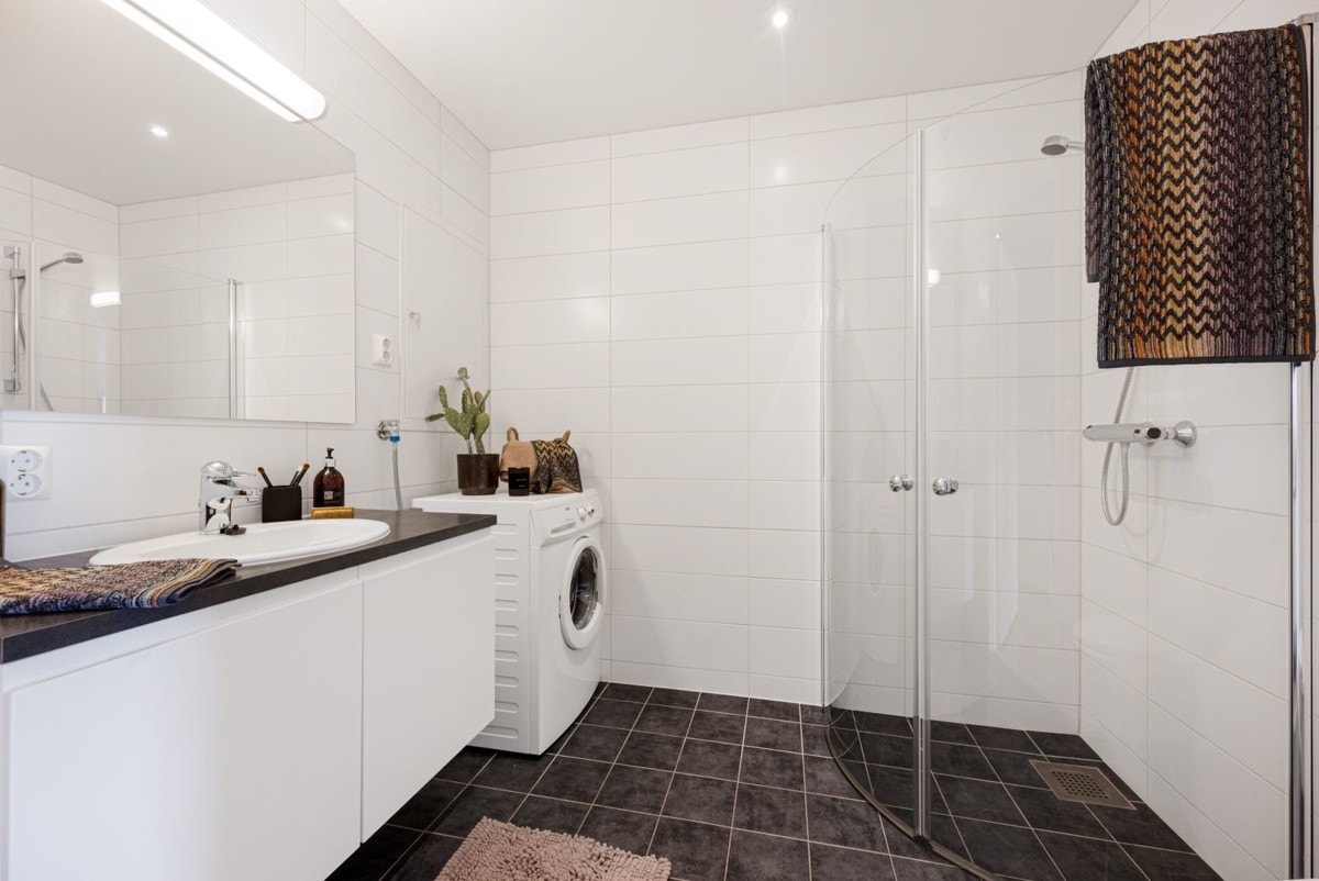 Meget lekkert bad med en nydelig baderomsinnredning, downlights i tak, varme i gulv, dusjhjørne og opplegg for vaskemaskin