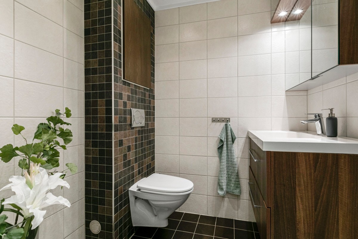 Badet fra 2010 er romslig og innbydende med en pen kombinasjon av lyse og mørke fliser på gulv og vegger. Galleribilde