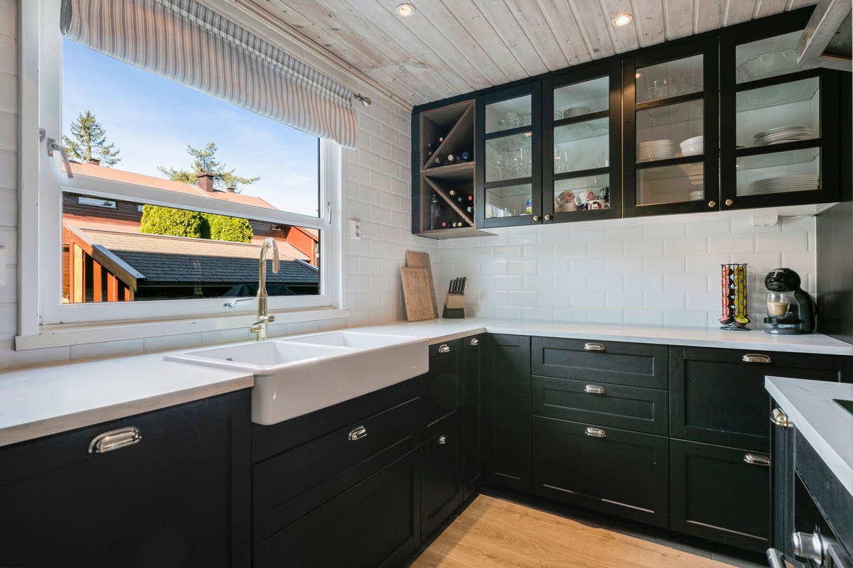 Lekre "kaffe-fliser" over kjøkkenbenken gir kjøkkenet et lunt og gjennomført uttrykk. Det er rikelig med oppbevaringsplass i skuffer og skap som gjør det enkelt å holde orden. Galleribilde