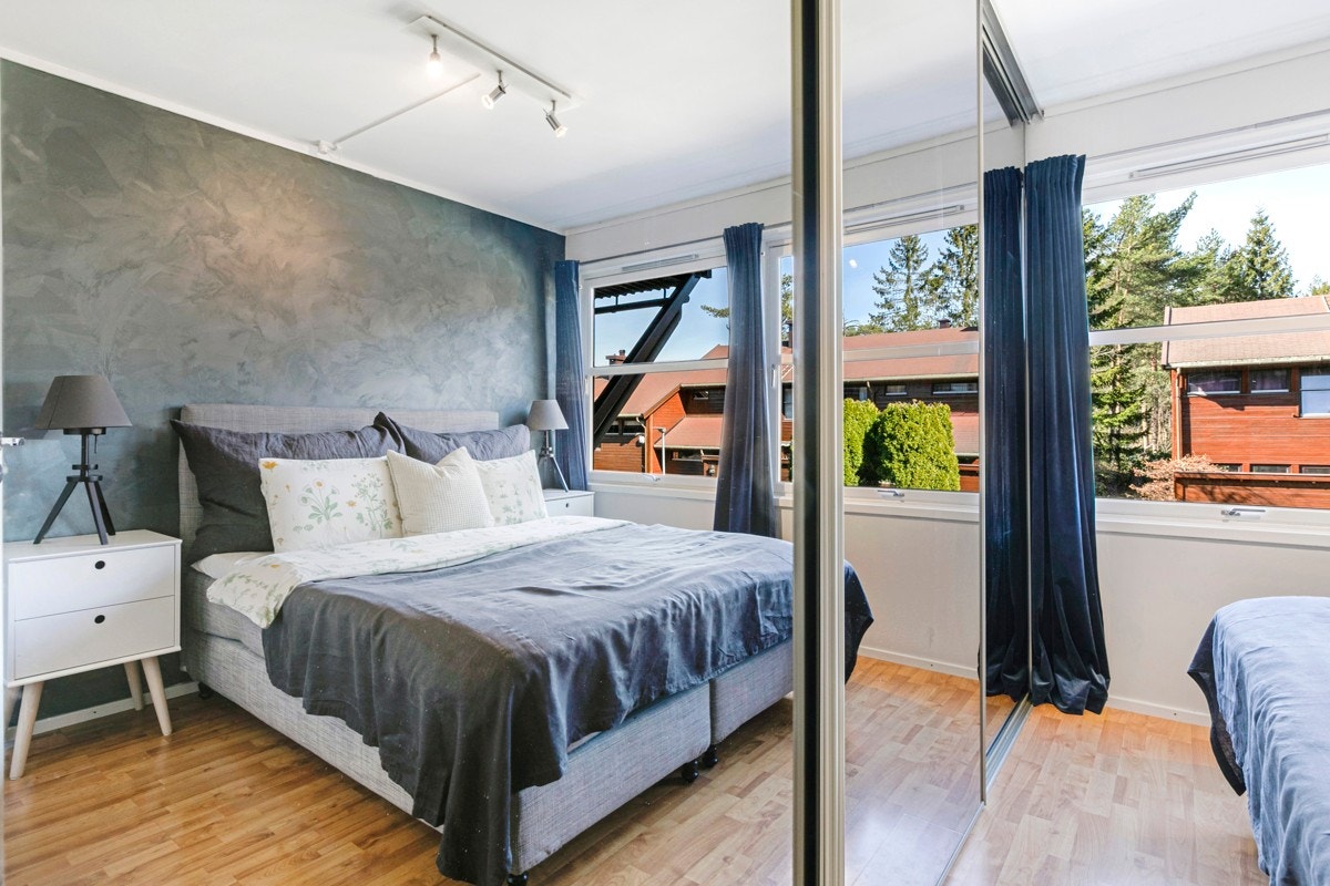 Hovedsoverommet er lyst og innbydende med god plass til dobbeltseng og tilhørende nattbord på hver side. Langs den ene langveggen er det etablert en stor skyvedørsgarderobe med speilfronter som maksimerer plassutnyttelse og forsterker romfølelsen. Galleribilde