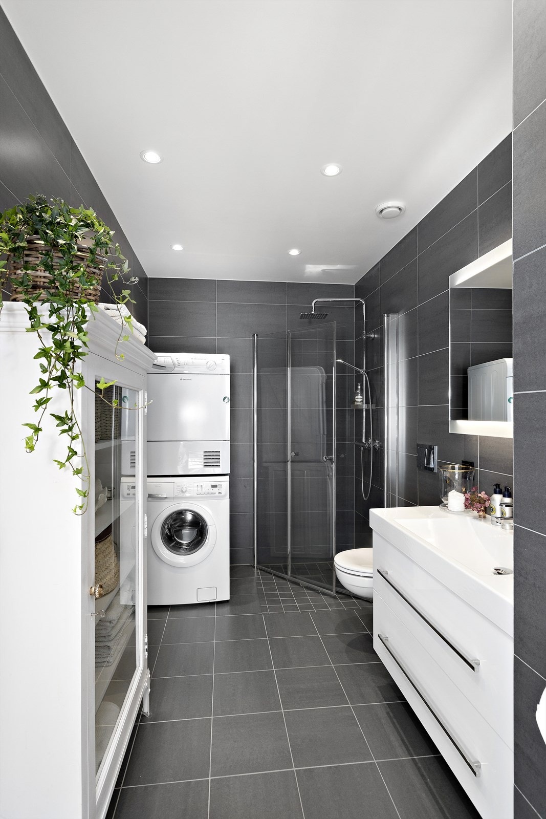 Lekkert og moderne hovedbad. Innredet med dusj med vannfallsdusj, hånddusj og innfellbare glassvegger, helstøpt servant i innredning med skuffer under, speil med belysning samt vegghengt toalett Galleribilde