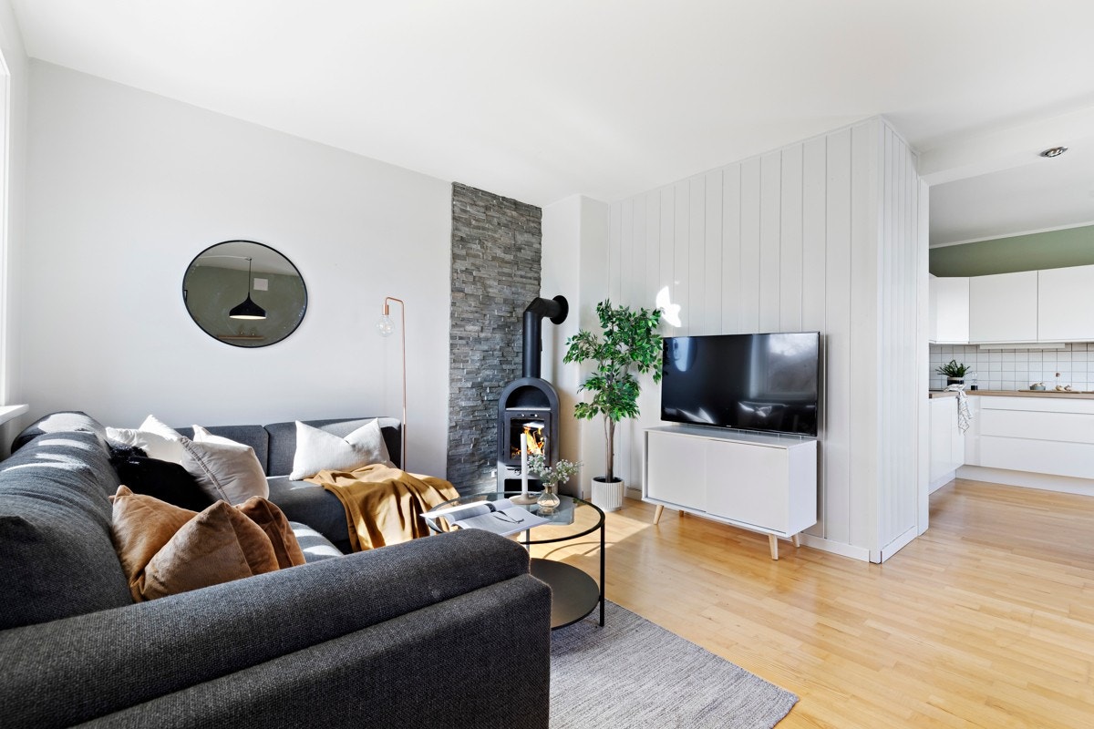 Stuen ligger i en delvis åpen løsning mot kjøkkenet, noe som gir et sosialt og romslig allrom. Galleribilde