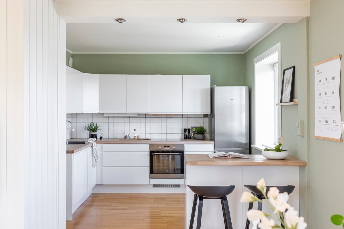 Kjøkkenet har god benke- og skapplass. Innredningen har lyse slette fronter og heltre benkeplate som gir et pent og gjennomført inntrykk. Galleribilde