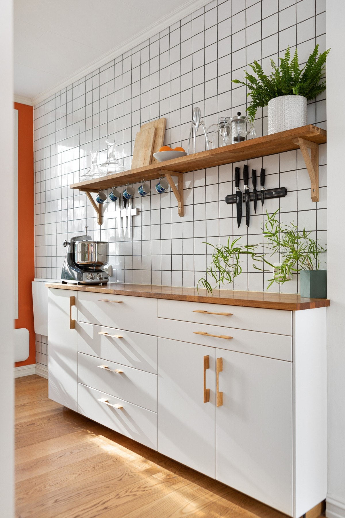 Fliser, belysning og stikkontakt over kjøkkenbenk. Galleribilde