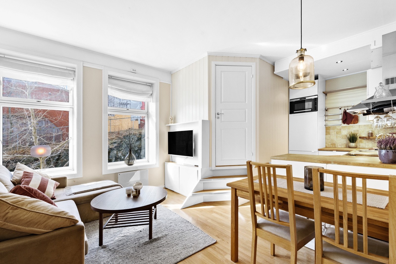 Åpen stue/kjøkken-løsning. Det er ekstra høyt under taket og de to store vinduene gir mye naturlig lys og en god romfølelse. Galleribilde