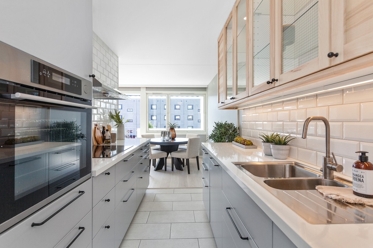 Kjøkkenet har integrerte hvitevarer med bl.a. stekeovn i praktisk arbeidshøyde i høyskap, oppvaskmaskin og bred induksjonstopp (80 cm). Galleribilde