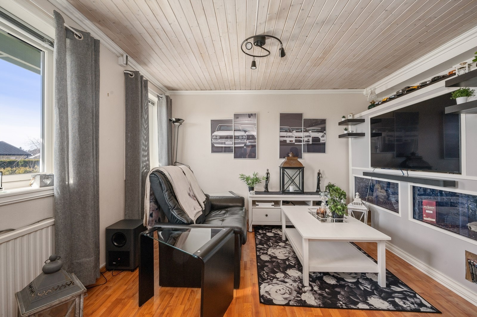 Stue i hybel med store vindusflater og vedovn. Galleribilde