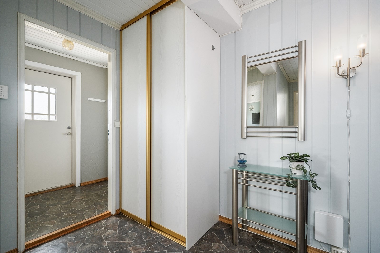 Vindfanget tar deg inn til en romslig hall med trapp med god plass til å henge fra seg yttertøy i skyvedørsgarderobe. Galleribilde