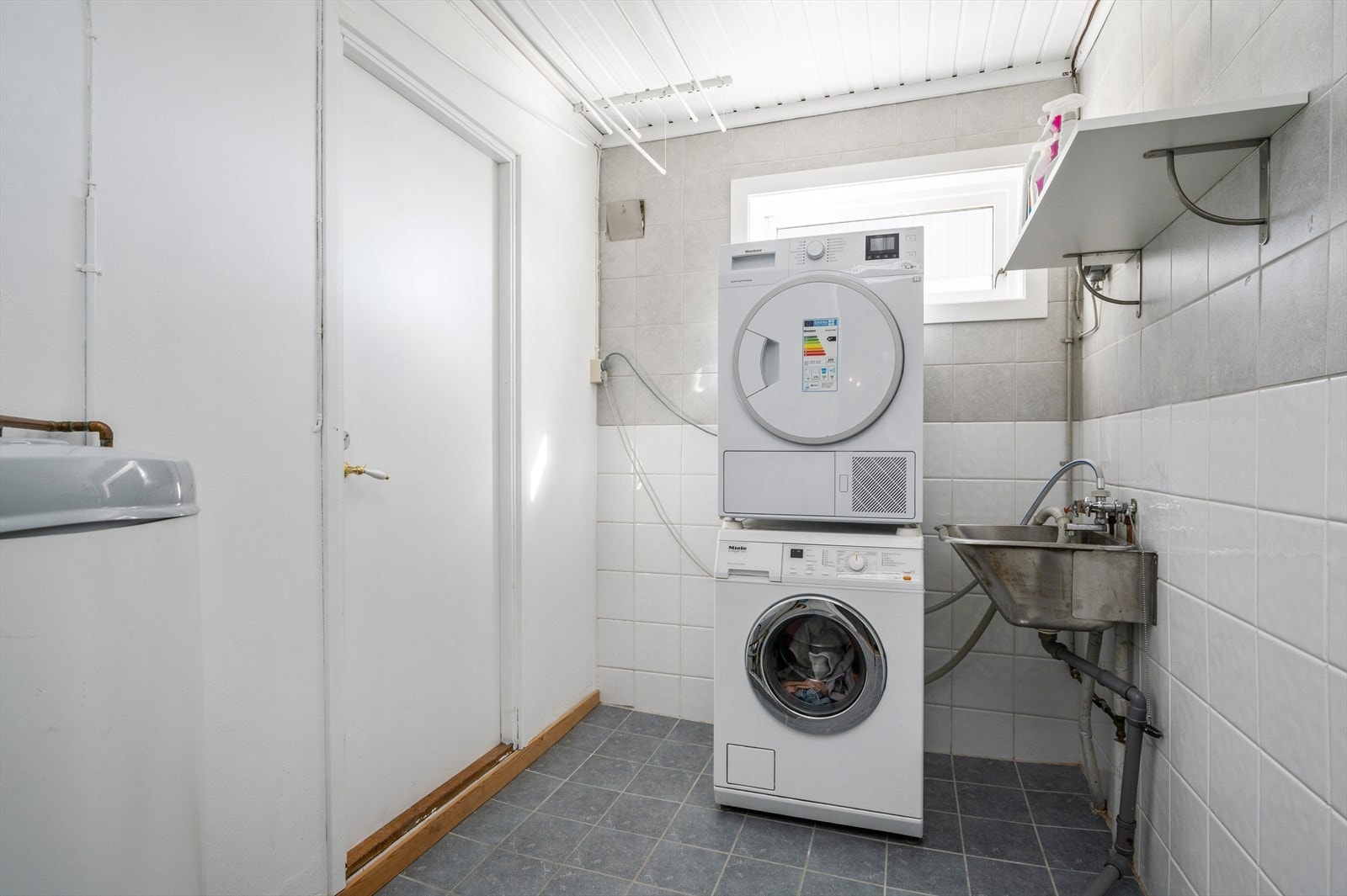 Eldre separat vaskerom i underetasjen med flislagte overflater og gulvvarme. Galleribilde