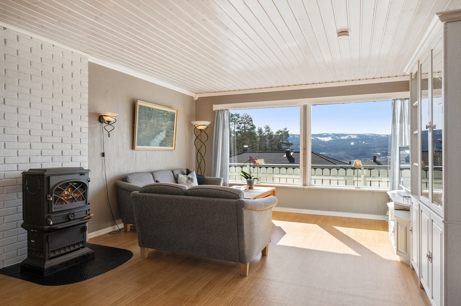 Stuen har en peisovn som varmer godt på kjølige kvelder i tillegg til en luft til luft varmepumpe som bidrar til et jevnt inneklima året rundt. Galleribilde