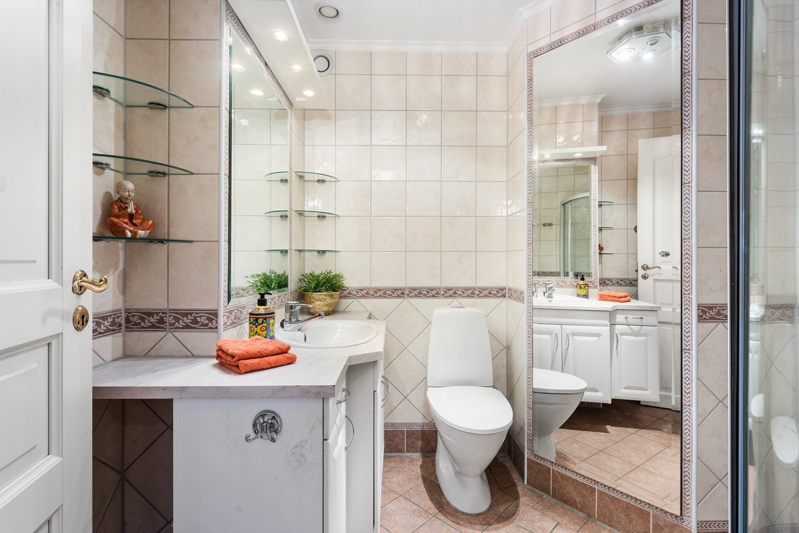 Innredningen består av servant nedfelt i laminat benkeplate på benkeseksjon med profilerte fronter, speil med overlys og toalett (ca 2017). Galleribilde