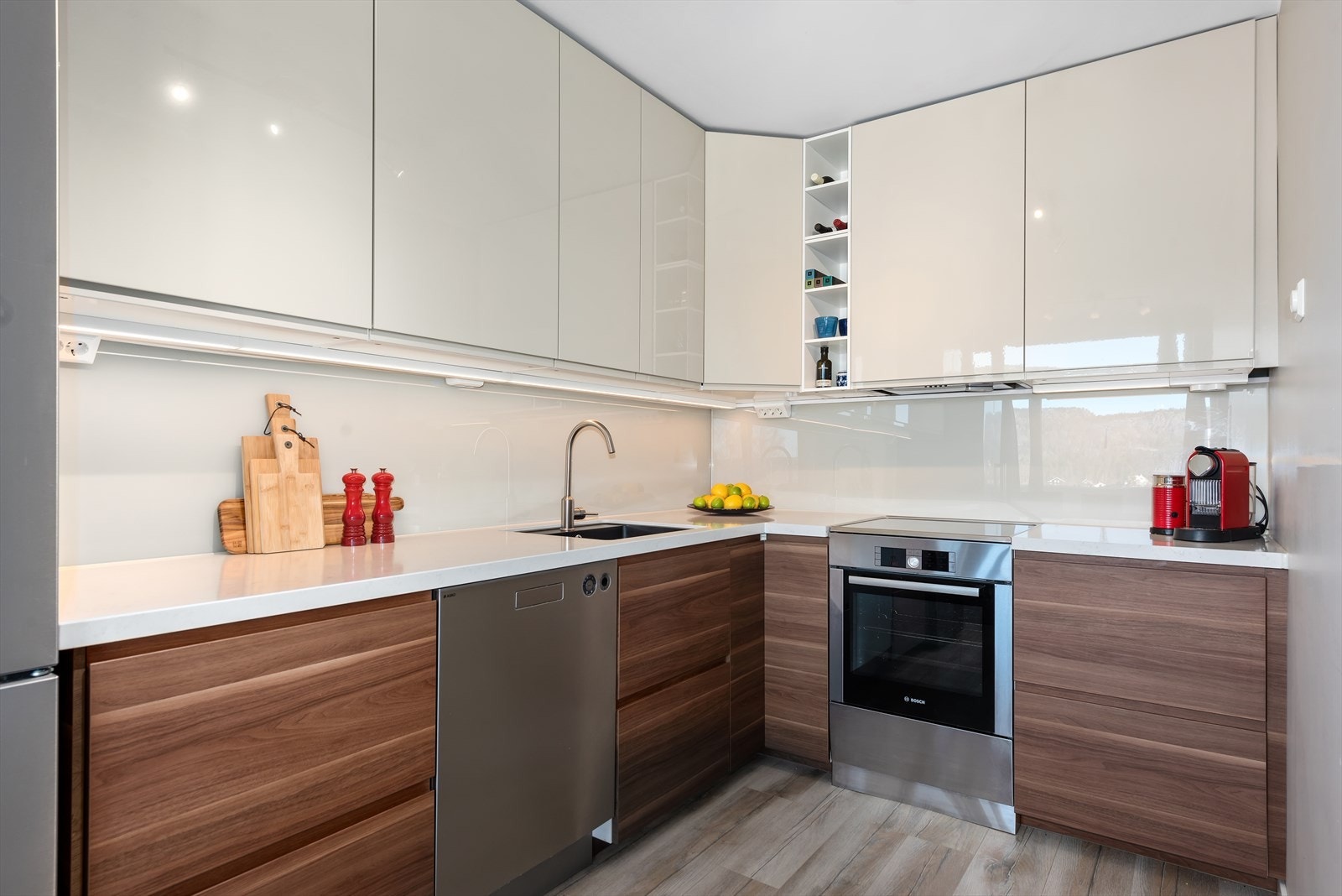 Kjøkkenet er lyst og moderne med høyglanset fronter og belysning under overskapene. Galleribilde