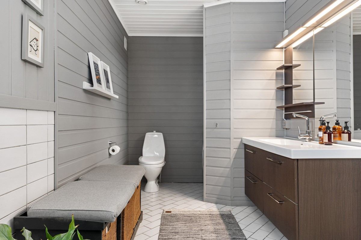 Badet i 1.etasje fremstår som resten av boligen svært moderne med en mørk innredning, gulvmontert toalett og dusj