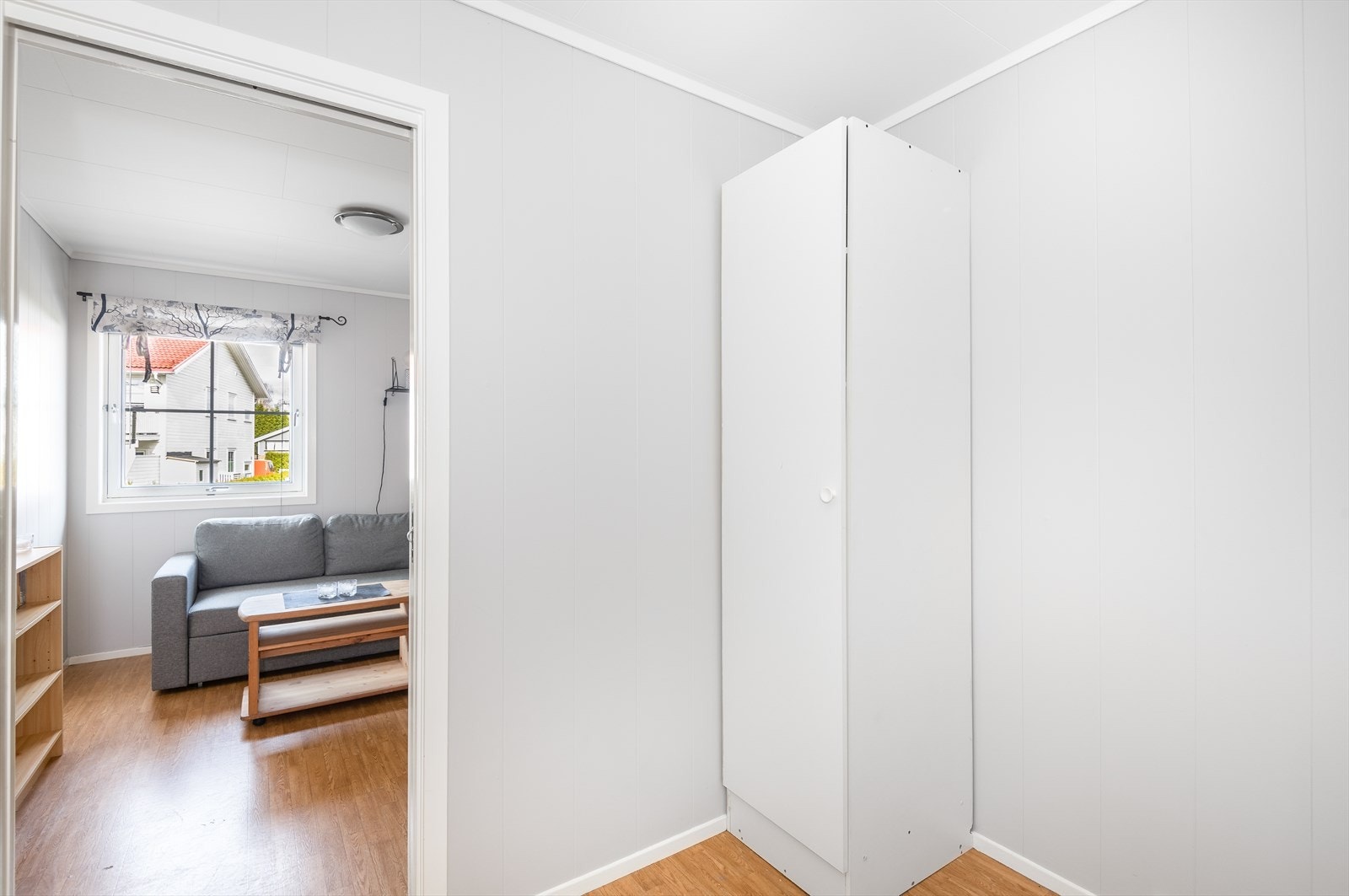 Walk-in closet med belegg på gulv og ellers malte overflater. Det er trapp opp til loft hvor det er lagt gulv, og det er god lagringsplass Galleribilde