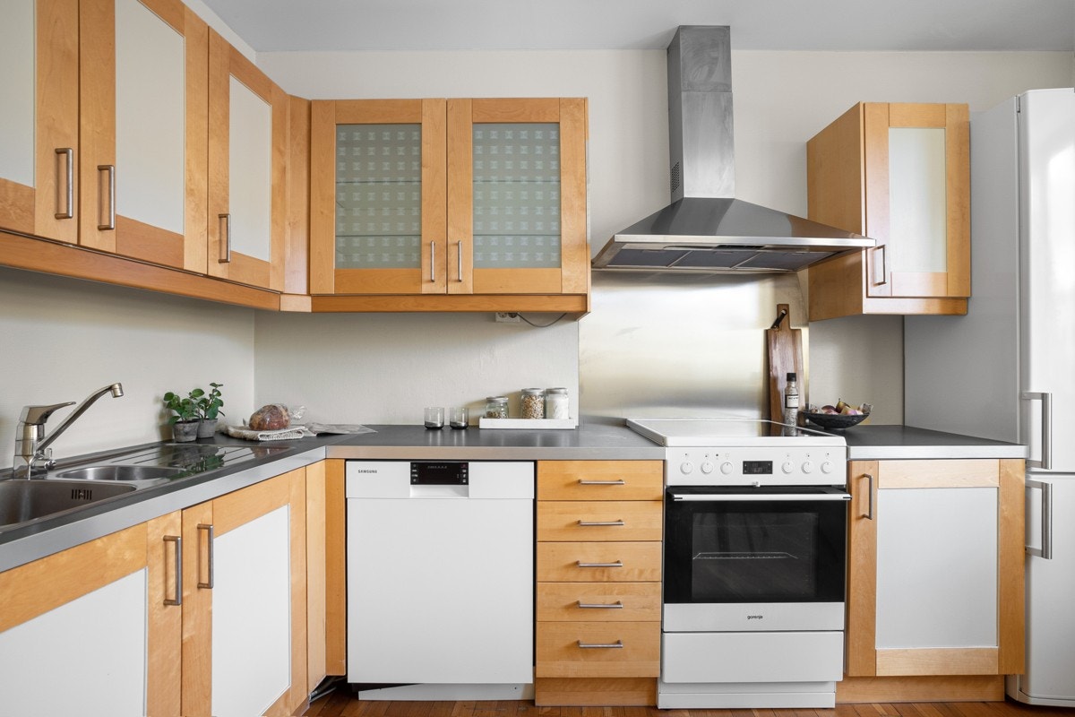 Romslig kjøkkeninnredning med mye skap- og benkeplass. Galleribilde