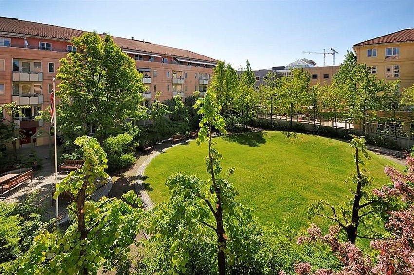 Bakgården er omkranset av grønne omgivelser. Galleribilde