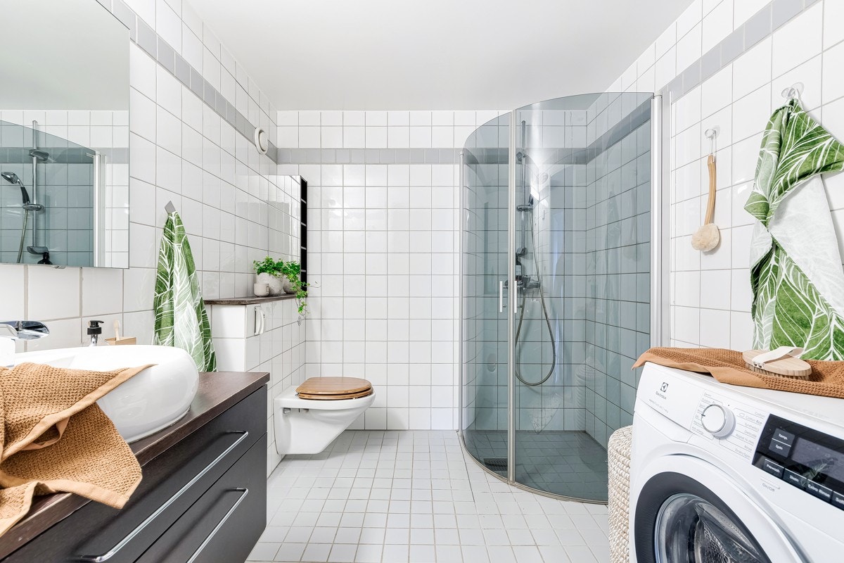 Romslig bad med lyse, tidsnøytrale fliser. Galleribilde