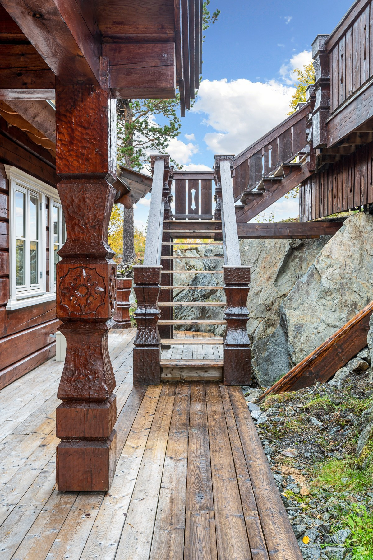 På baksiden av hytten er det trapp opp til stor terrasse og anneks