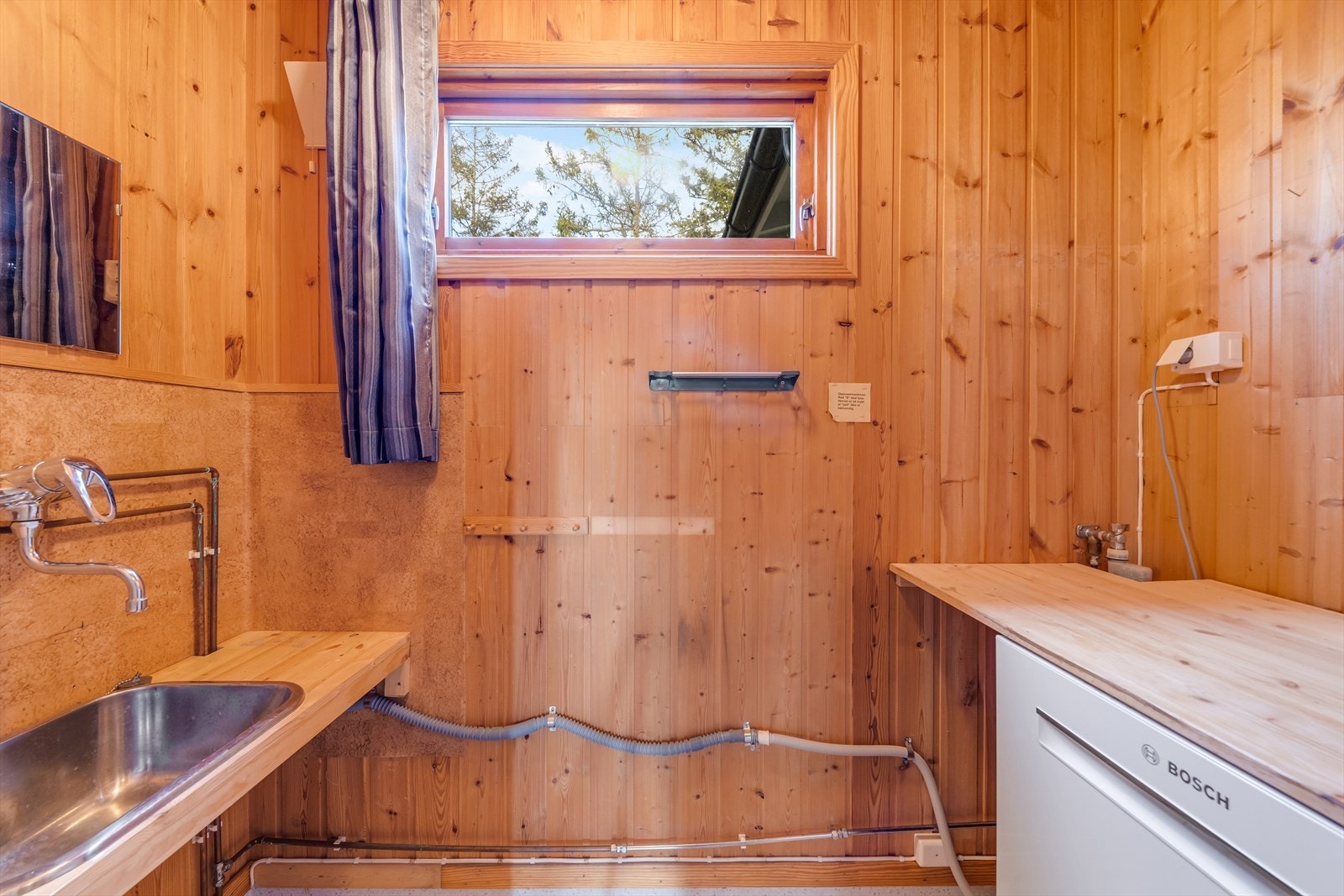 I hytta er det et eget, praktisk vaskerom med skyllekum og arbeidsbenk. Galleribilde