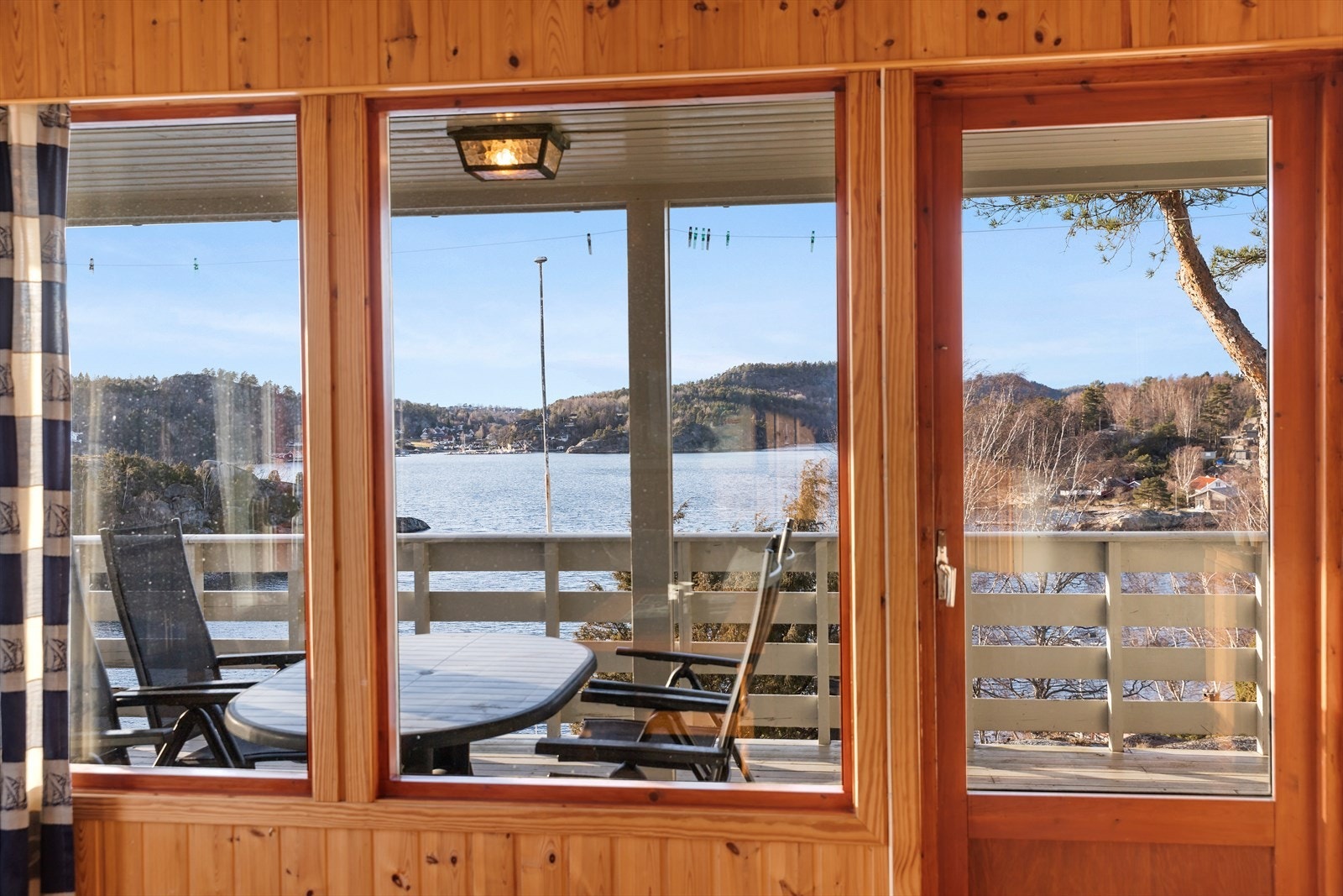 Store vinduer sørger for rikelig med naturlig lys til stuen, samtidig som de ivaretar den nydelige sjøutsikten. Galleribilde