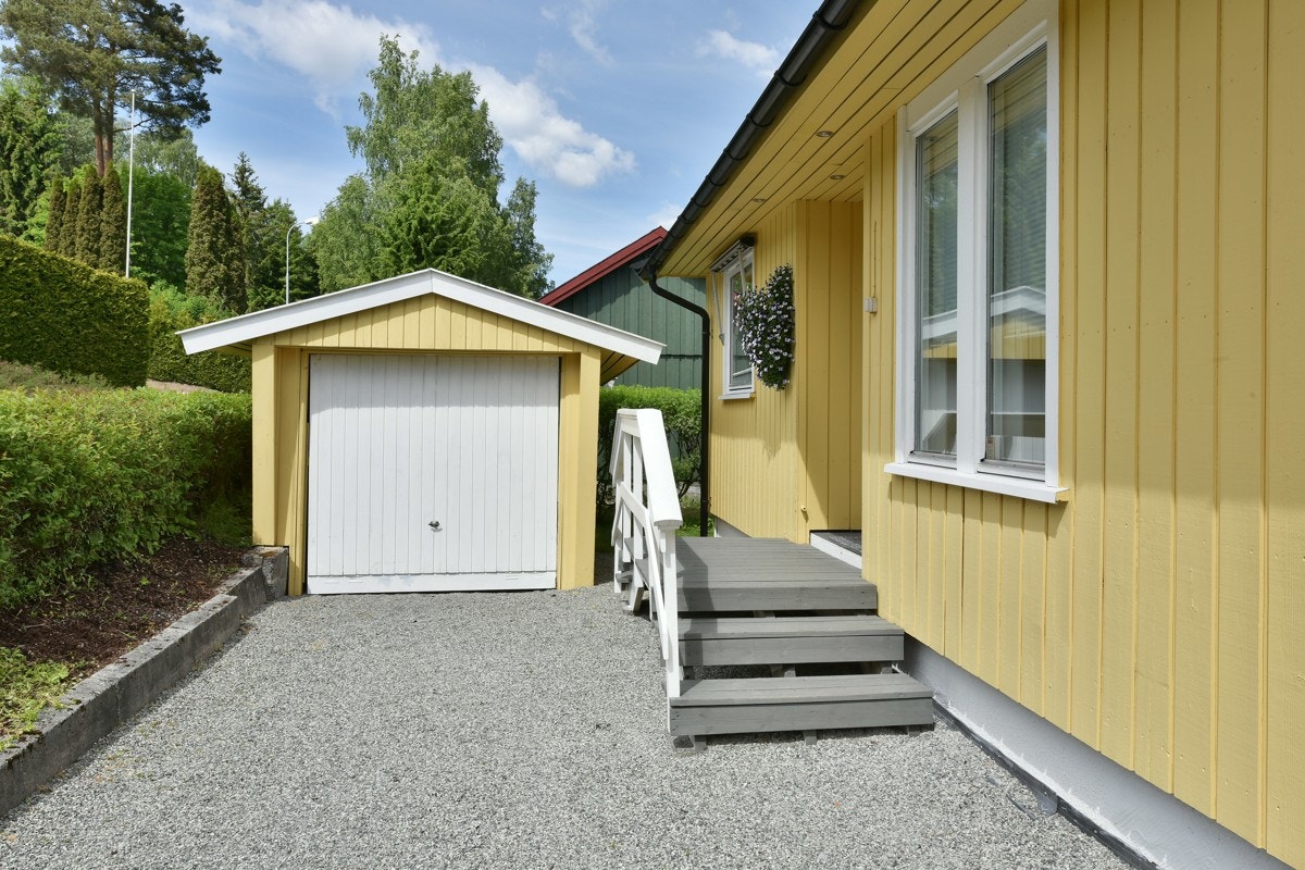 Det er parkering i en frittstående garasje med vippeport. Galleribilde