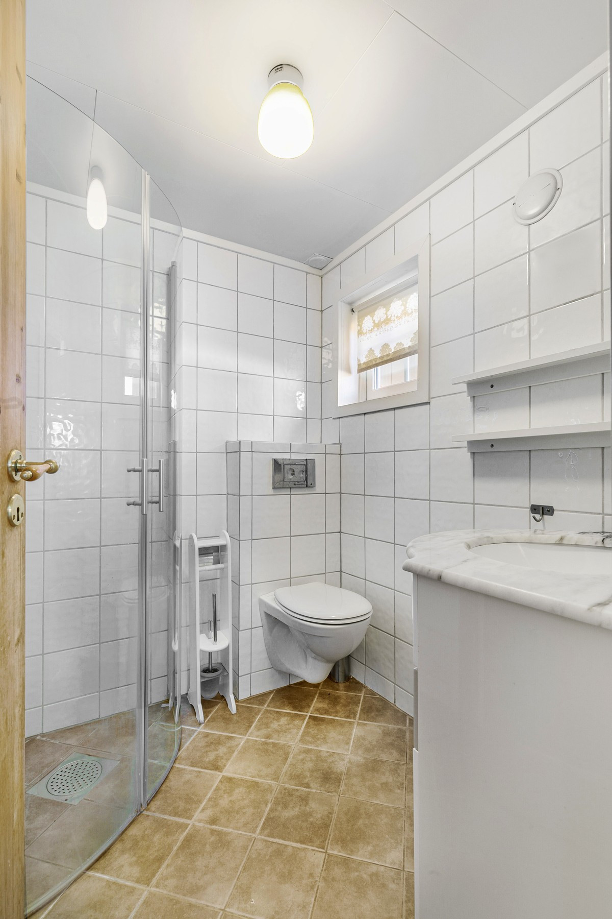 Badet i 1.etasje har flislagt gulv og gulvvarme