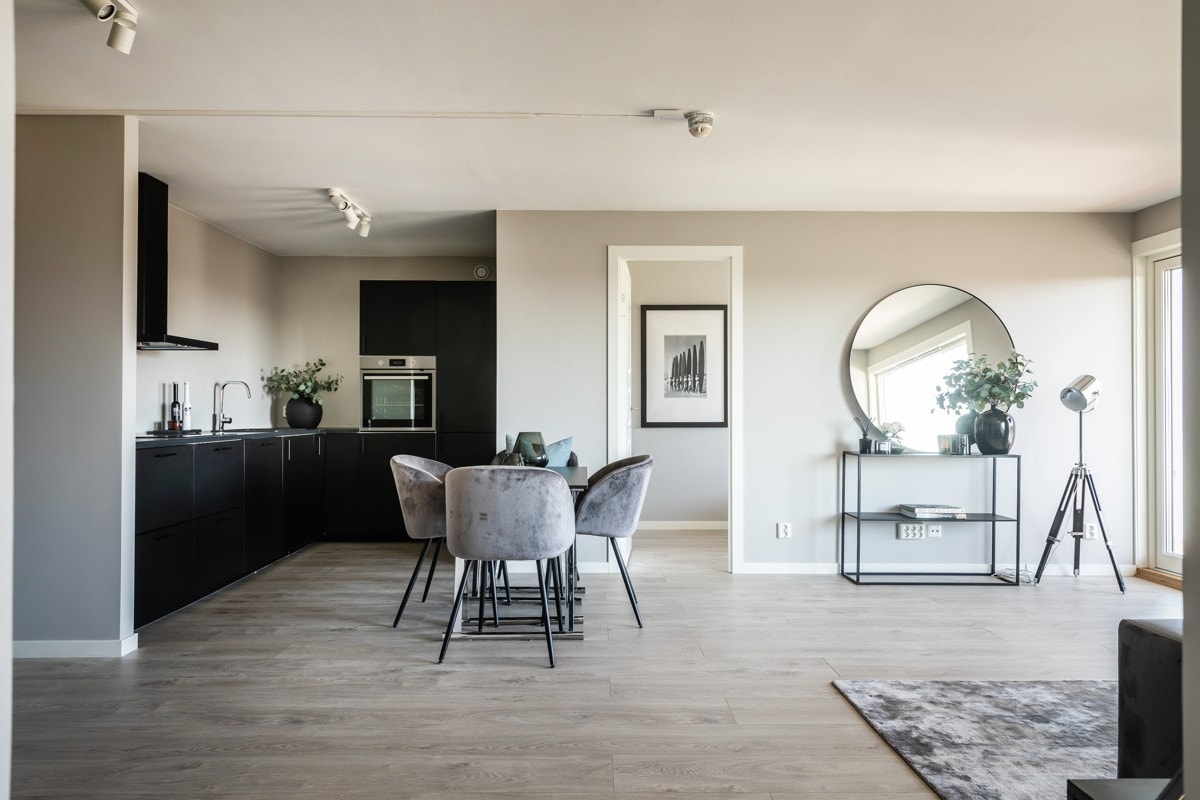 Kjøkkenet er plassert i eget hjørne som gir tydelig inndeling mellom sone for spisestue/stue og kjøkken Galleribilde